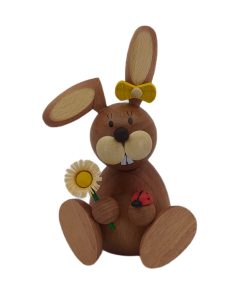 Osterhäsin sitzend mit Marienkäfer und Blume